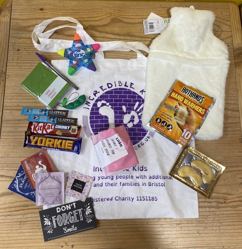 Tote bag on a table with a selection of goodies around it